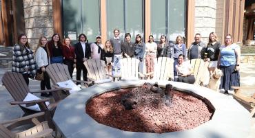 Hospitality and Tourism Management students with their instructors on a sunny day outside with a fire pit and wooden chairs in front at the Ritz-Carlton in Truckee, CA.