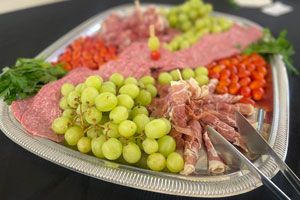 Cafe Verde catering charcuterie board with Genoa Salami, Prosciutto di Parma, Cherry tomatoes, Seasonal Grapes