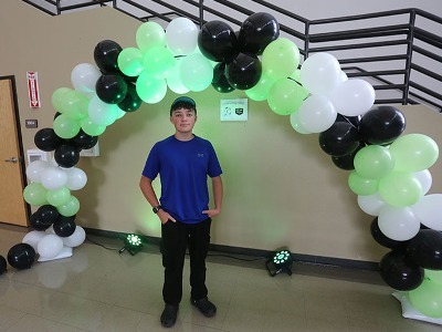 Carlton Antisdel stands for a photo underneath the balloon gate inside the Student Center.