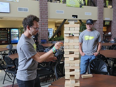 Christopher Westin watches his colleague Alexander Day, both Counseling staff, try pulling a log from the Jenga tower on Spirit Day.