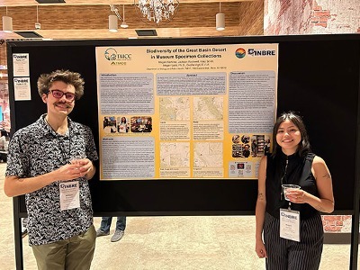 Jackson Rockwell and Megan Ramirez stand proudly beside their extensive research poster board at the INBRE statewide meet.