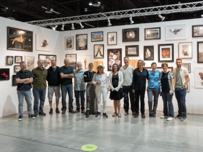 TMCC students, faculty, and staff pose for a photo in an art gallery.