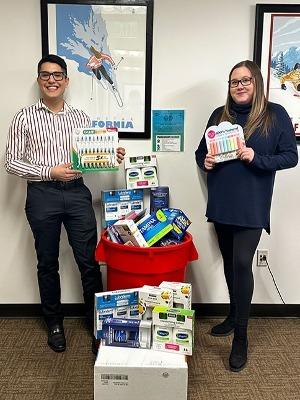 Jaime Gudino, BE-Club Secretary, and Sarah Fricke, Human Resources Generalist at The Ritz-Carlton, Lake Tahoe, smile while holding up the generous contributions.