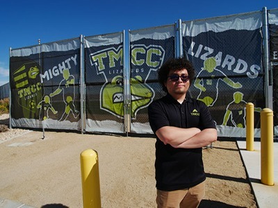 Cruz Trujillo stands proudly outside the TMCC Soccer Field gates, where his stylish windscreens welcome the Mighty Lizards, challengers, and fans.
