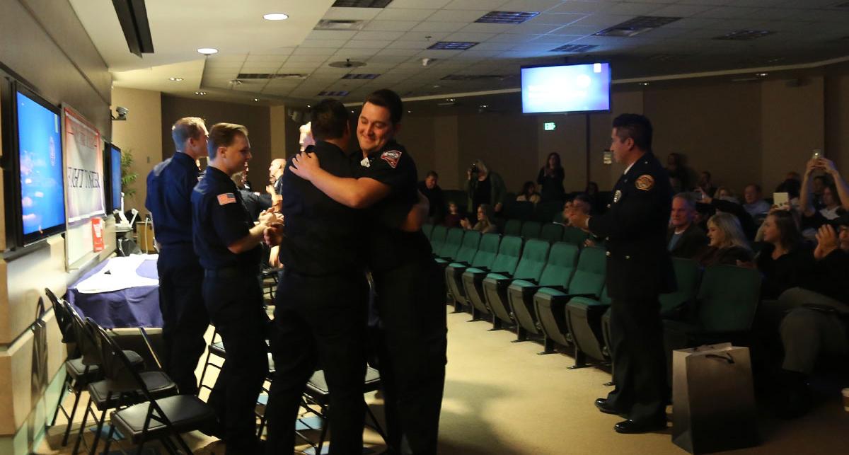 Cadets hugging at the fire academy graduation.