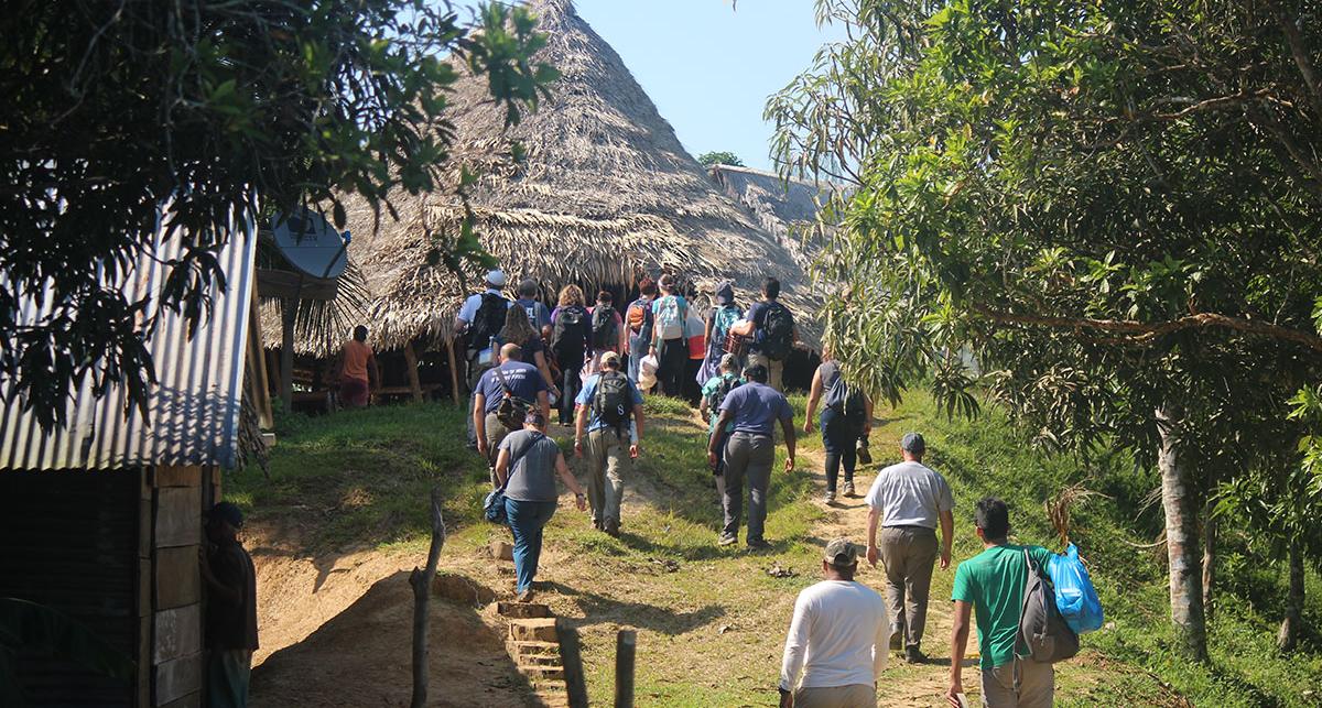 group of volunteers walking up to a hut