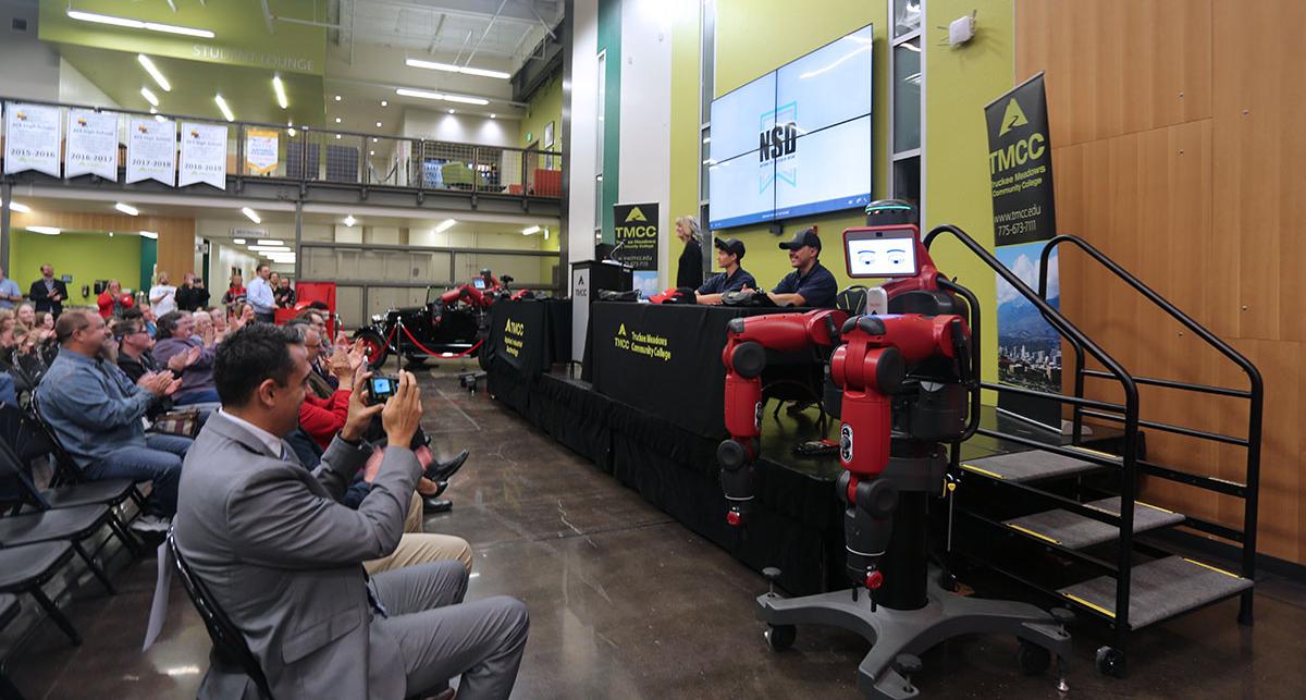 Guests applauding students on stage at the NC3 event.