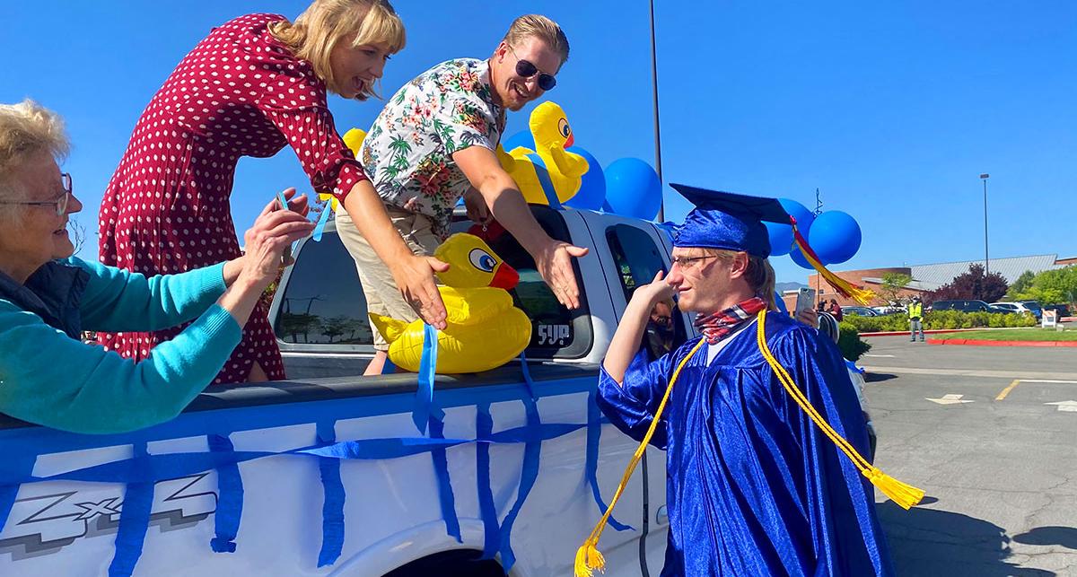 family celebrates with graduate in cap and gown