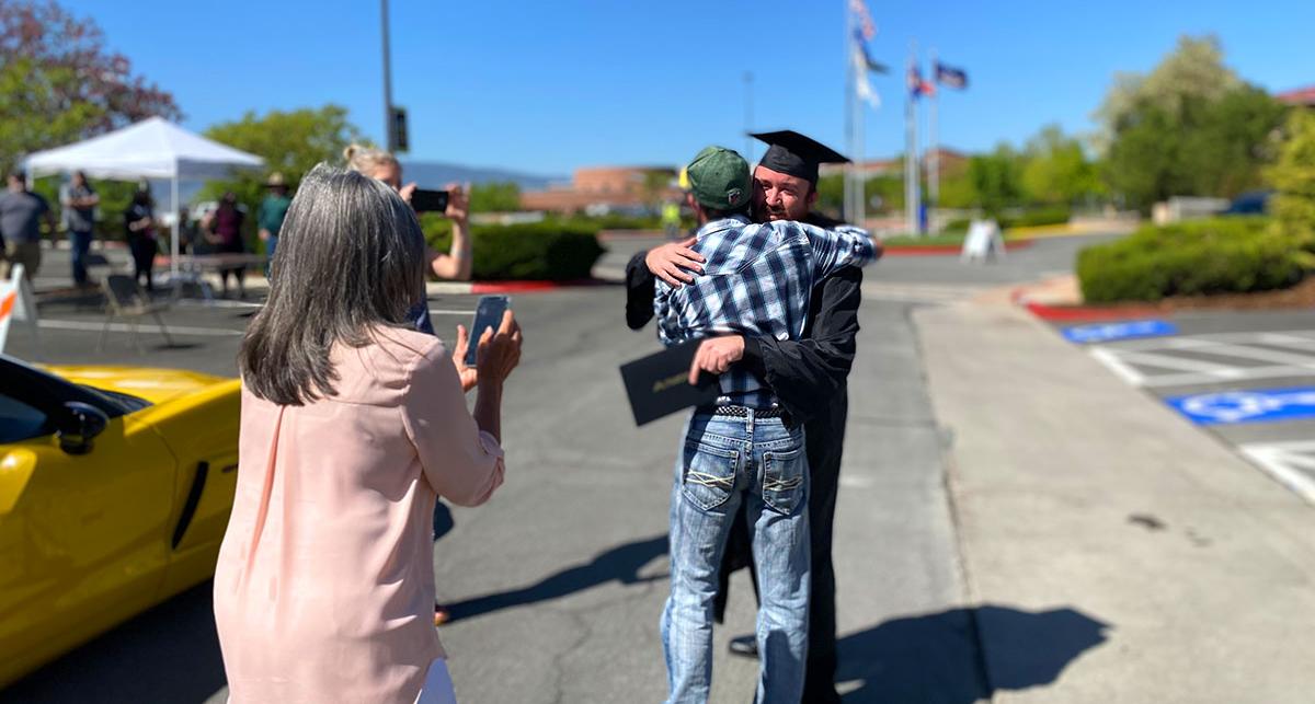 family embraces graduate at 2021 commencement ceremony