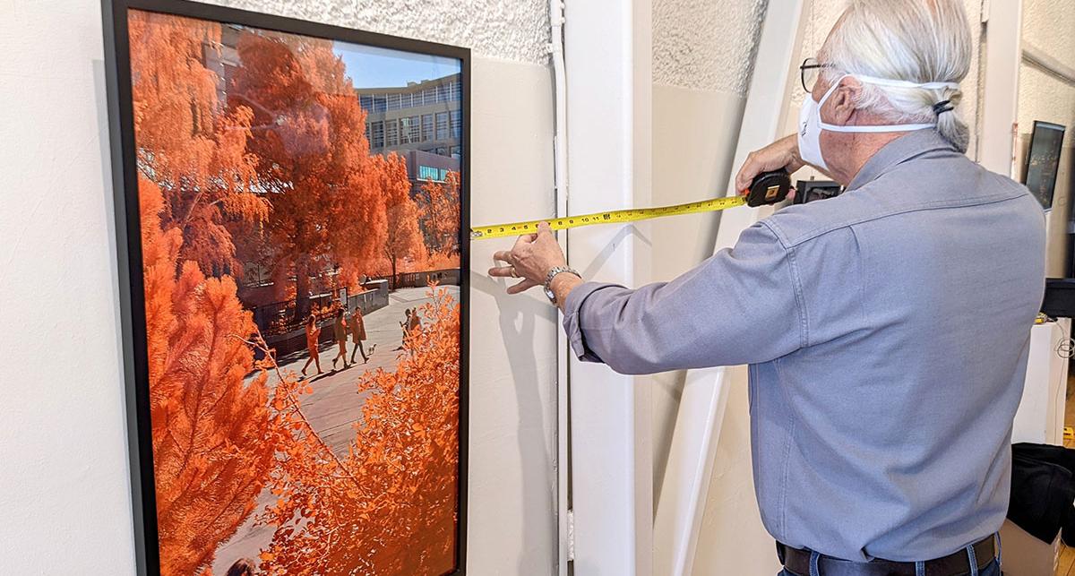 Artist hanging a photo in a gallery.