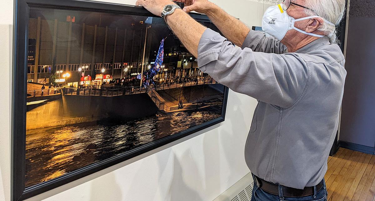 Artist hanging a photo in a gallery.