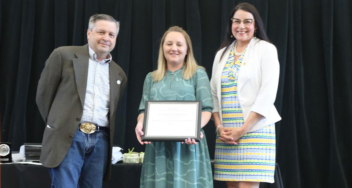 Regent Jason Geddes and President Hilgersom present Advisor Courtney Schachter her award.