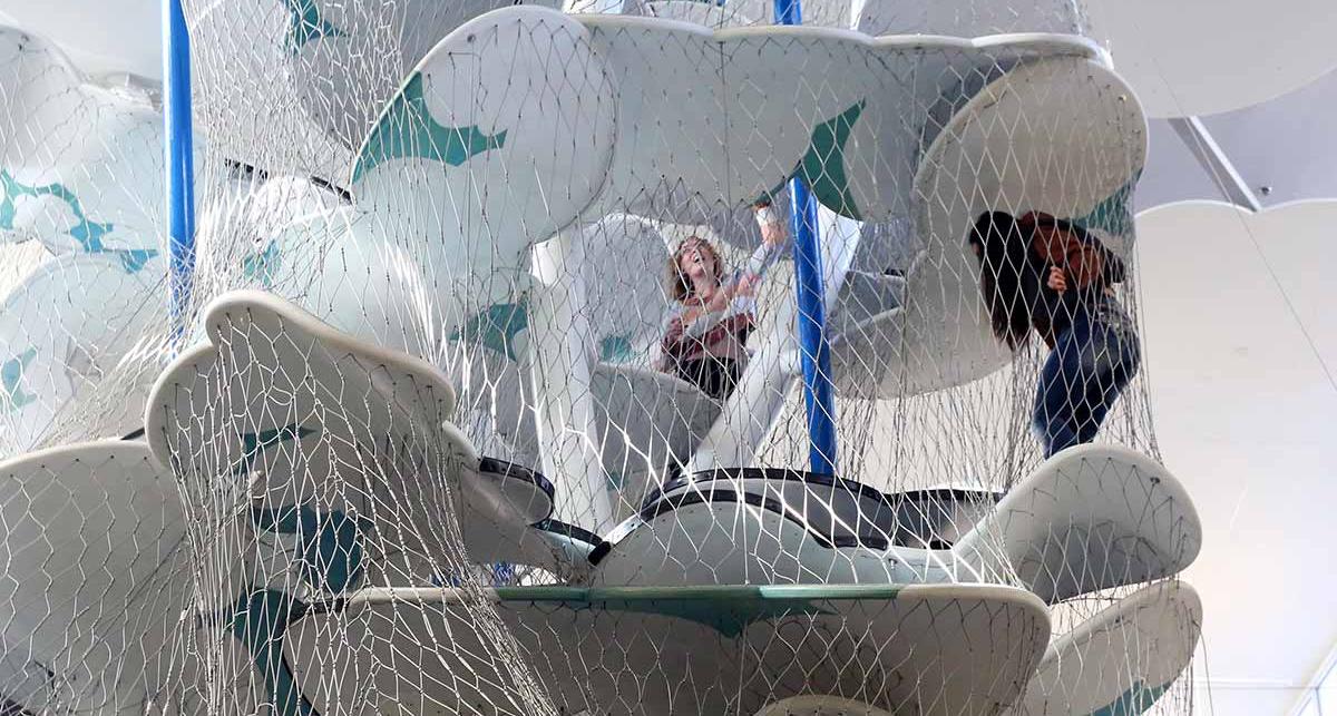 Two students climbing a cloud shaped structure. 