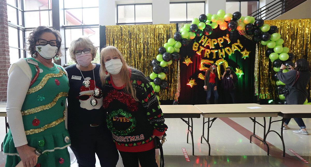 Holiversary guests wearing festive sweaters.