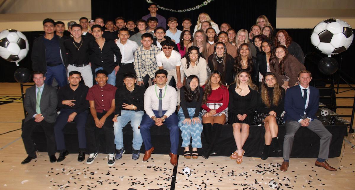 Student-athletes pose with Athletics Director/Head Coach Geoff Hawkins.