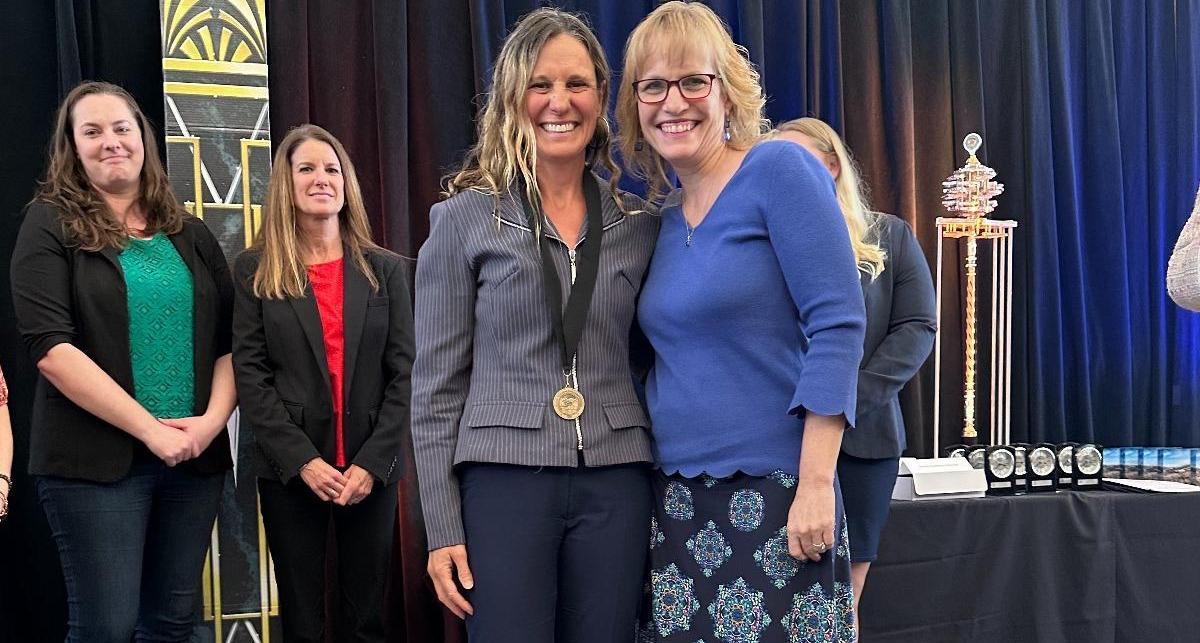 Amy Williams awards Vanina Coudriet with a medal for her newly tenured faculty status.