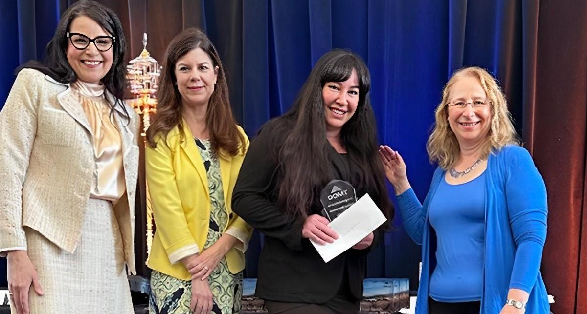 Dr. Karin Hilgersom, Gretchen Sawyer, and Dr. Mindy Lokshin present Adine Stormoen with the TMCC Faculty Excellence in Service Award.