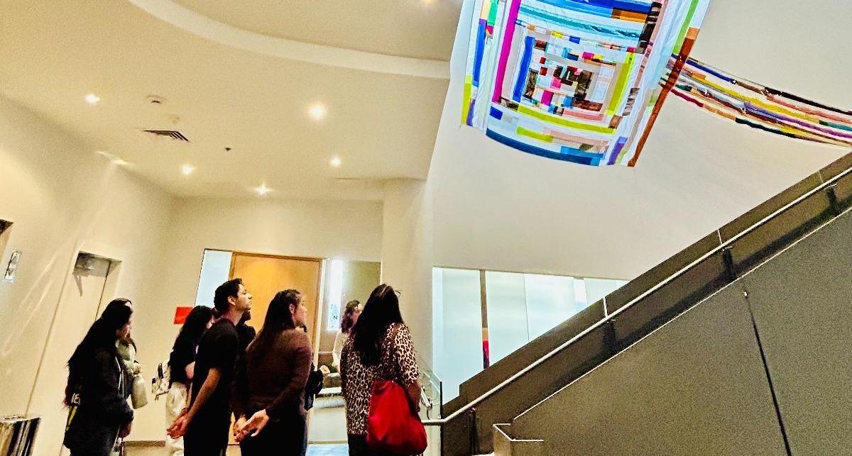 Students admire play of light in textile installation by artist Rachel Hayes.