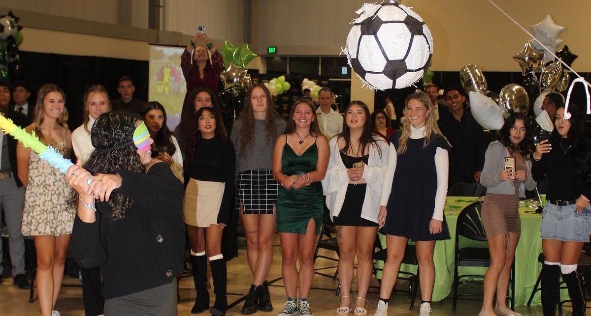 The Men's and Women's Soccer players enjoy hitting a piñata shaped like a soccer ball.