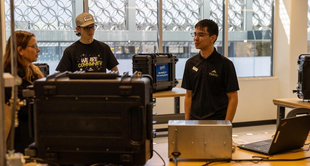 Students converse while interacting with the high-tech equipment during the event.