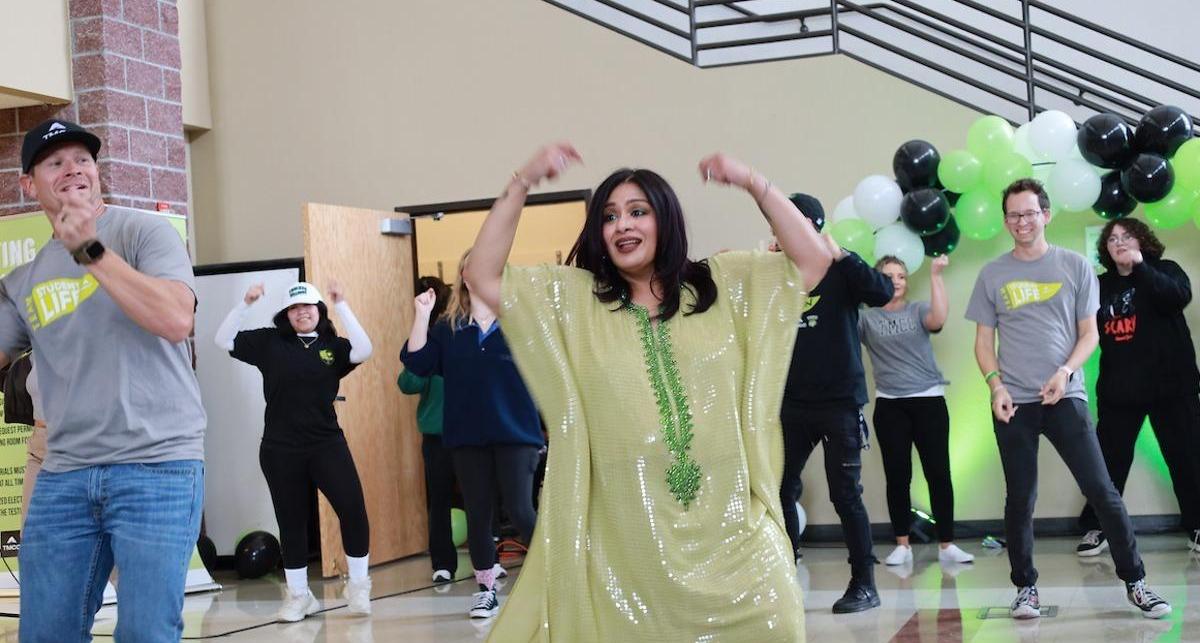 A dance instructor adorning a dazzling kurta shows TMCC members India's energetic Bollywood moves.