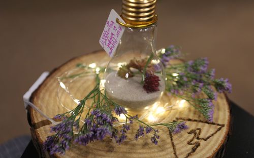 A light bulb in a handmade centerpiece reads "Our future is bright because of you!"