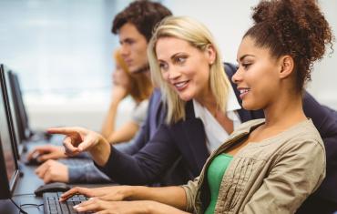 Teacher helping student on computer