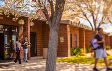 Students walking outside a brick building.