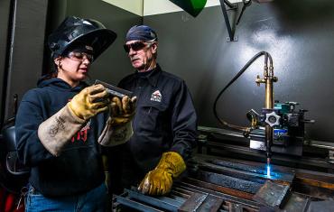 Student showing teacher their weld