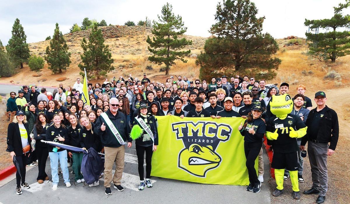 A massive, smiling group of TMCC students, leadership, faculty, and staff, including Mayor Ed Lawson of Sparks, stand united for a historic, encompassing group photo on the marching path.