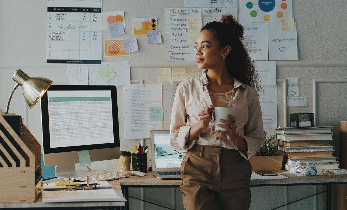 A woman pauses thoughtfully in her business office.