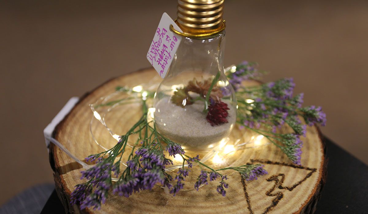 A light bulb in a handmade centerpiece reads Our future is bright because of you!