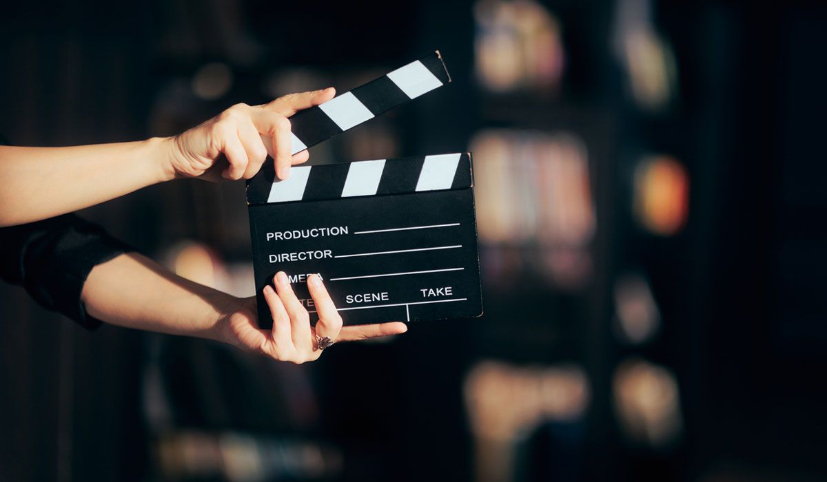 Hands holding a clapperboard used by filmmakers.