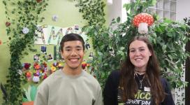 Ayden Rodriguez and Taylor Easley smile for a photo within their gorgeous, mystical forest-themed decorated office.